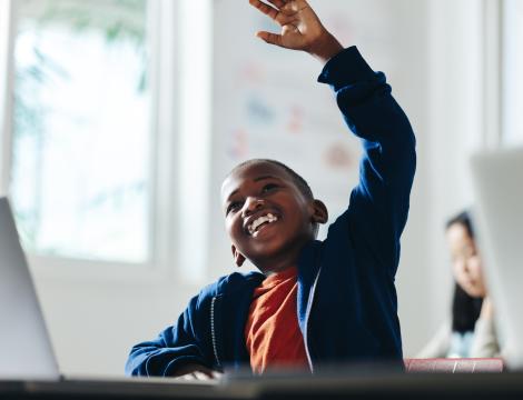 Child raising hand in classroom